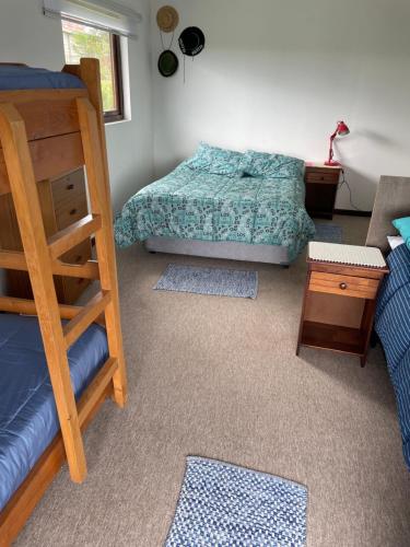 a bedroom with a bed and a bunk bed and a ladder at Casa Sra Oti, Tipo Hostal con vista al mar Puerto Montt - CHINQUIHUE in Puerto Montt