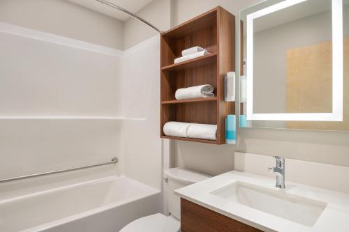 a bathroom with a sink and a toilet and a mirror at Park Inn by Radisson, Kelowna in Kelowna