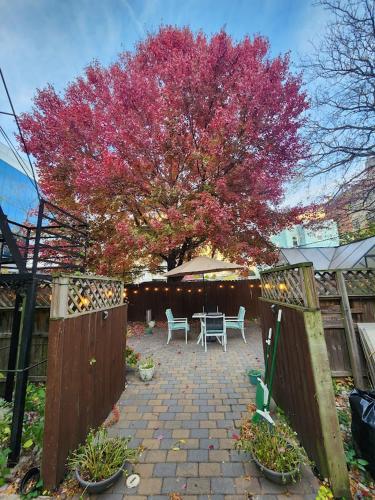 a garden with a table and a tree with pink leaves at Magnolia Stay near New York City in Jersey City