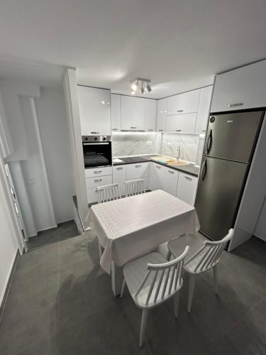 テッサロニキにあるAngelのテーブルと椅子と冷蔵庫のあるキッチン