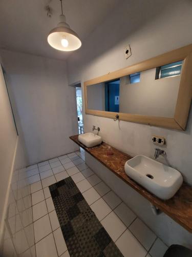 a bathroom with two sinks and a mirror at Nomad Hostel - Vila Madalena in São Paulo