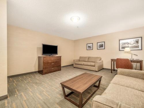 a living room with a couch and a tv at Holiday Inn Lethbridge by IHG in Lethbridge