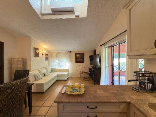 a kitchen and living room with a couch and a table at La Fuente del Pedregal Casa 1 - Lago y piscinas in Málaga