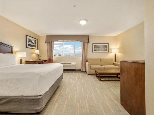 a hotel room with a bed and a couch at Holiday Inn Lethbridge by IHG in Lethbridge