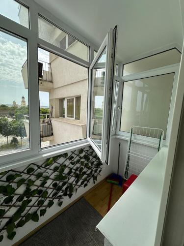 a room with a large window and a white table at Karolina Apartment in Alba Iulia