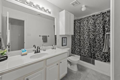 a bathroom with a sink and a toilet and a mirror at Keller's Gem House & Spa in Keller