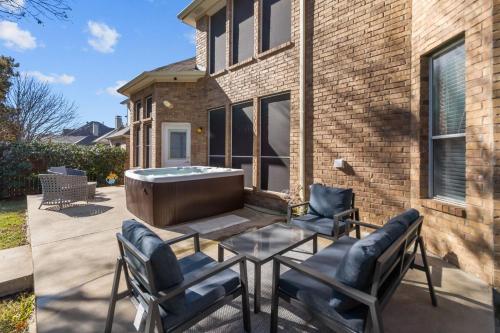 a patio with a table and chairs and a tub at Keller's Gem House & Spa in Keller