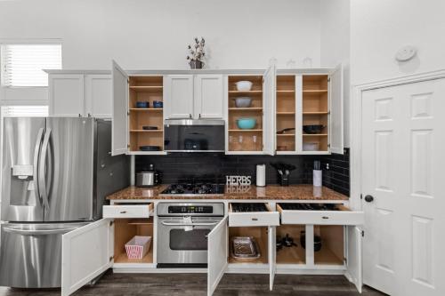 a kitchen with white cabinets and a stainless steel refrigerator at Keller's Gem House & Spa in Keller