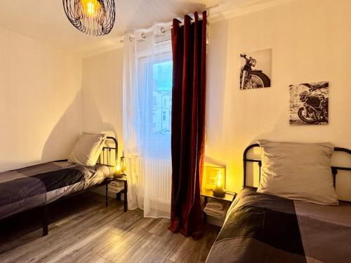 une chambre avec deux lits et une fenêtre dans l'établissement L 'atelier, Fonderie district, à Mulhouse