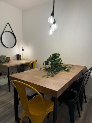 une table de salle à manger avec des chaises jaunes et une plante dessus dans l'établissement L 'atelier, Fonderie district, à Mulhouse