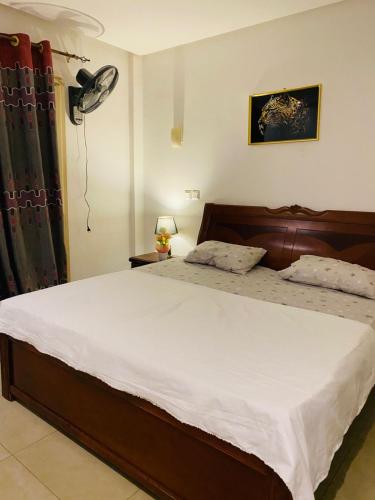 a bedroom with a large bed with white sheets at Sonu at home in Dakar