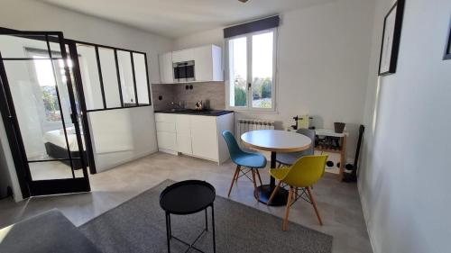 a kitchen with a table and chairs in a room at Le repaire de Barbizon in Barbizon