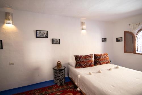 a bedroom with a large bed and a window at Dar YAMINA RASELMA in Chefchaouene