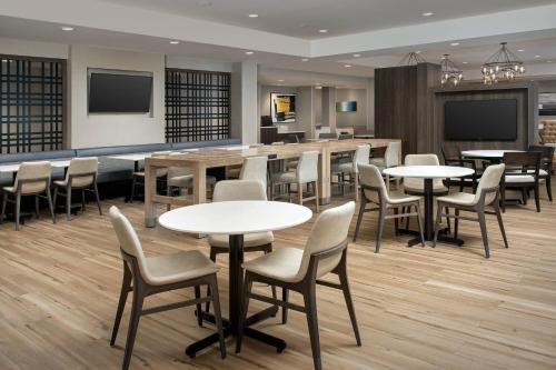 a restaurant with tables and chairs and a bar at Residence Inn Doral Mall Area in Doral