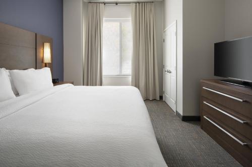 a hotel room with a large bed and a flat screen tv at Residence Inn Walnut Creek in Walnut Creek