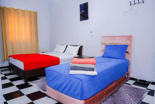 a bedroom with two beds and a checkered floor at Spacious Apartment with Motorcycle Garage, Free Parking, and Air Conditioning in Er Rachidia