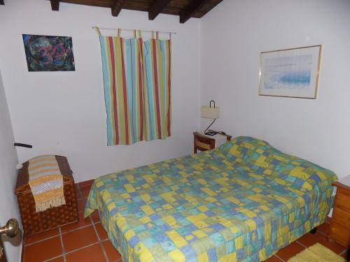 a bedroom with a bed and a chair in it at Casa da Felicidade in Pataias