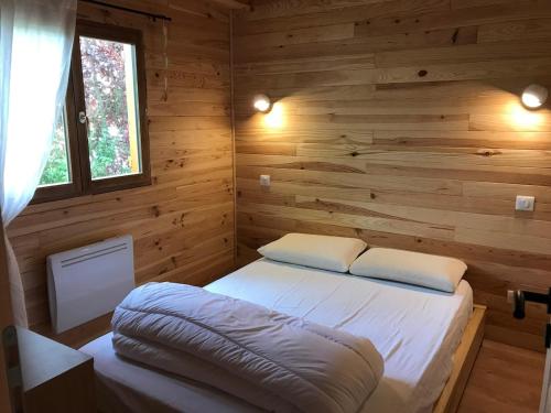 Cette chambre comprend un lit dans une cabane en rondins. dans l'établissement Chalet individuel pied des pistes 8 personnes, à Saint-Léger-les-Mélèzes