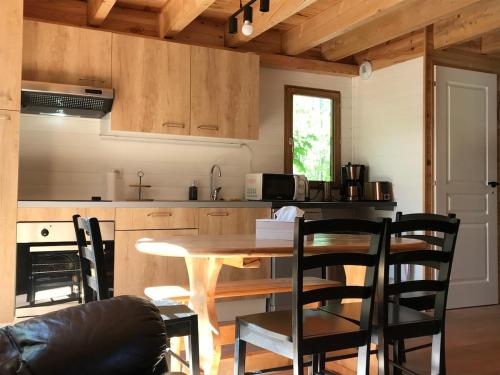 une cuisine avec une table et des chaises dans une pièce dans l'établissement Chalet individuel pied des pistes 8 personnes, à Saint-Léger-les-Mélèzes