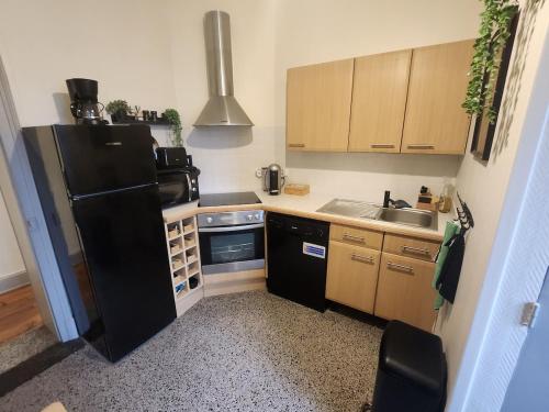 Elle comprend une petite cuisine équipée d'un réfrigérateur noir et d'un évier. dans l'établissement L 'Échappée Cambrésienne, à Cambrai