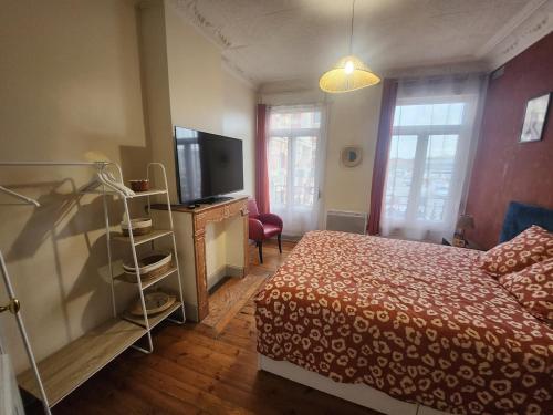 une chambre avec un lit et une télévision à écran plat dans l'établissement L 'Échappée Cambrésienne, à Cambrai