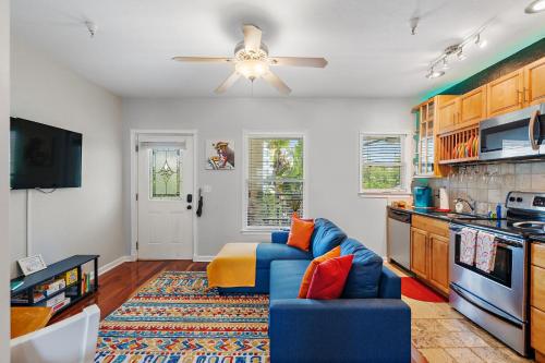 a living room with a blue couch and a ceiling fan at Itz a Vibe - 1 bedroom studio in the heart of DTSP in St. Petersburg
