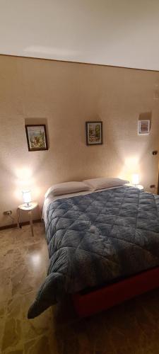 een slaapkamer met een bed met twee lampen aan de muur bij L'attico di Ovidio 2 in Sulmona