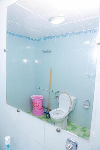 a bathroom with a toilet and a pink bucket at Spacious Apartment with Motorcycle Garage, Free Parking, and Air Conditioning in Er Rachidia