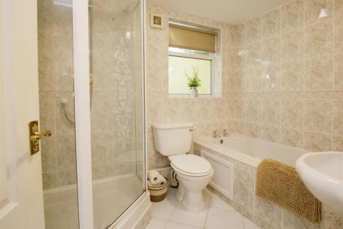 a bathroom with a toilet and a tub and a sink at Stylish apartment - 2 min walk from Ogmore by sea beach with private garden, sea views & stunning sunsets, dog friendly in Tythegston