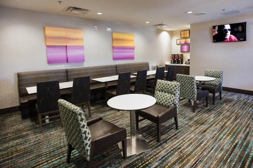 a waiting room with tables and chairs and a tv at Residence Inn by Marriott Lake Charles in Lake Charles