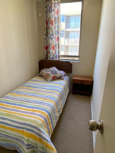 a small bedroom with a bed and a window at Lindo Depto 3 hab y 2 baños in Los Ángeles