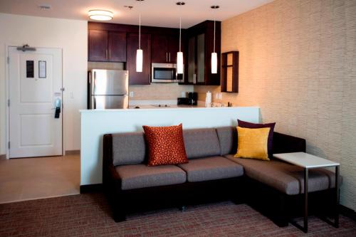 a living room with a couch and a kitchen at Residence Inn by Marriott Lake Charles in Lake Charles