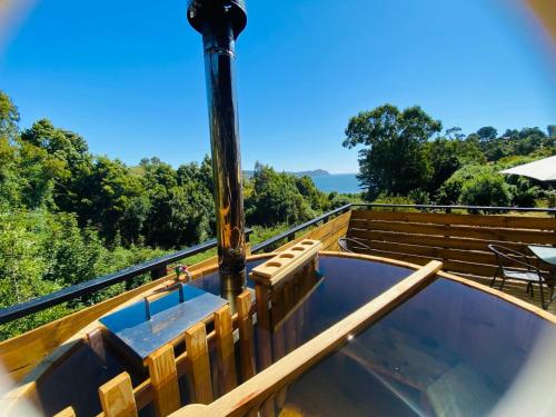 a hot tub on the deck of a house at Cabaña los arrayanes full equipada con Tinaja in Valdivia
