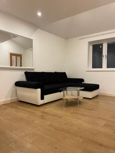 a living room with a black and white couch and a table at Hanwell serviced Accommodation in Greenford