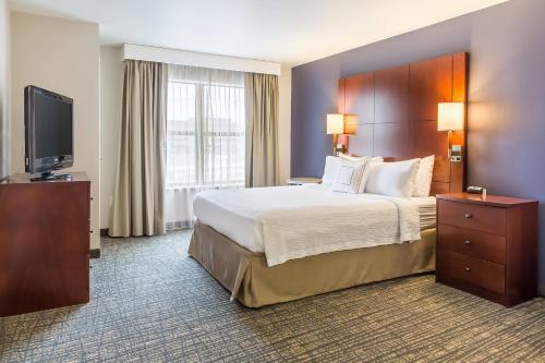 a hotel room with a bed and a flat screen tv at Residence Inn Lexington Keeneland/Airport in Lexington