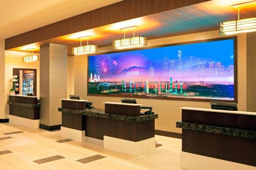 a hotel lobby with a large tv on the wall at Residence Inn by Marriott Los Angeles LAX/Century Boulevard in Los Angeles
