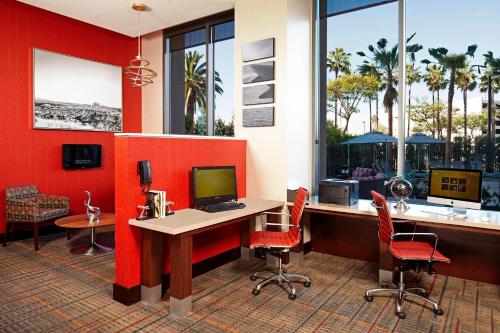 an office with red walls and a desk with a computer at Residence Inn by Marriott Los Angeles LAX/Century Boulevard in Los Angeles