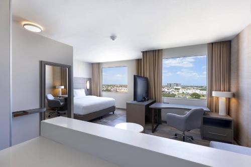 a hotel room with a bed a desk and a television at Residence Inn by Marriott Merida in Mérida