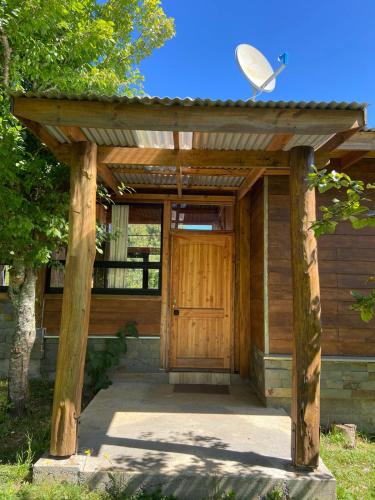 a wooden entrance to a house with a wooden door at Cabaña los arrayanes full equipada con Tinaja in Valdivia
