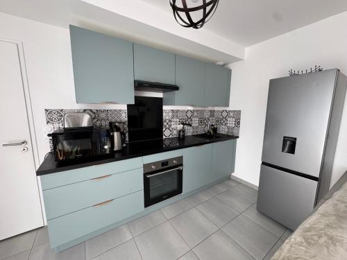  La cuisine est équipée de placards blancs et d'un réfrigérateur. dans l'établissement Casa Nomana 4 chambres, à Saint-Jean-de-Monts