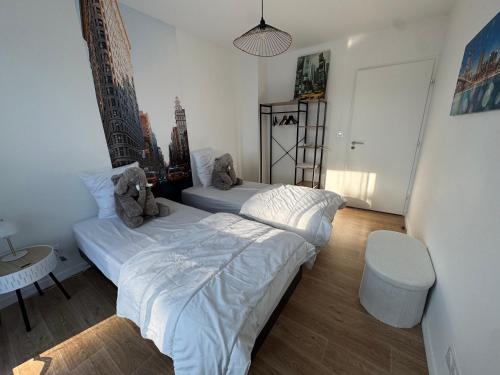 une chambre avec deux lits, une table et une chaise dans l'établissement Casa Nomana 4 chambres, à Saint-Jean-de-Monts