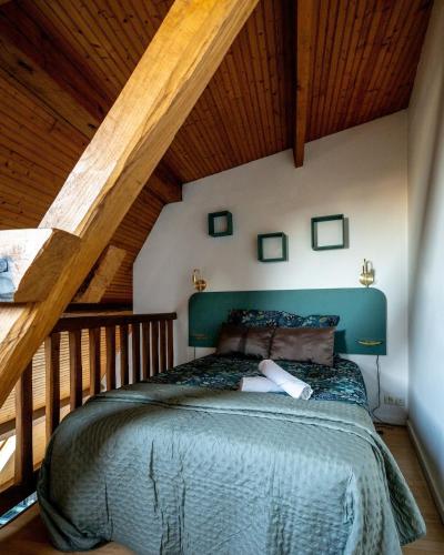une chambre avec un grand lit dans un grenier dans l'établissement Le Cocon sous les toits, à Beauvais