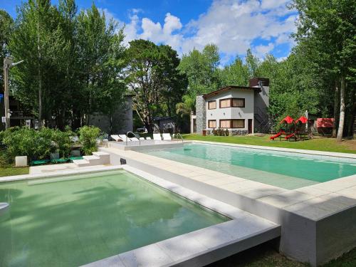 una piscina en un patio con una casa al fondo en Bosques del Este, en Costa del Este