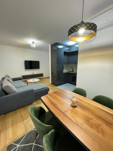 a living room with a table and a couch at Banja Luka Comfort - Wifi & Parking in Banja Luka
