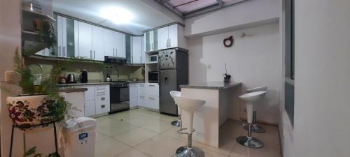 クスコにある"Departamento Entero y Céntrico para Parejas o Familia corta en CUSCO", Precio especial por mesの広いキッチン(白いキャビネット、白い電化製品付)