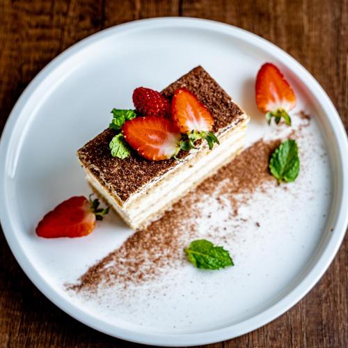 a piece of cake with strawberries on a white plate at The Skye Phnom Penh Hotel & Apartments in Phnom Penh