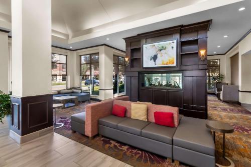 a living room with a couch and a tv at ACP Hotel Houston Westchase, MOD Collection by Sonesta in Houston