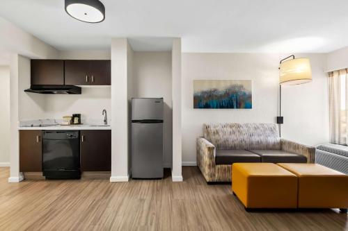 a living room with a couch and a kitchen at Sonesta Essential NW Houston in Houston