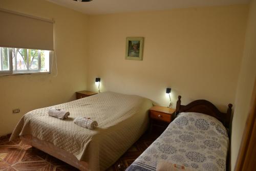 a small bedroom with two beds and a window at Departamentos temporarios La Nueva Costanera in Posadas