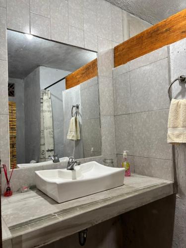 a bathroom with a white sink and a mirror at Hotel SPA Campestre Los Adobes in Taxco de Alarcón
